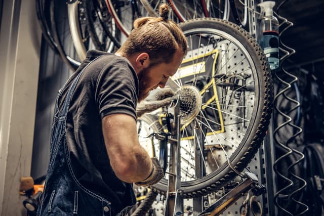 Fietsenmaker is bezig met de reparatie van een moderne e-bike