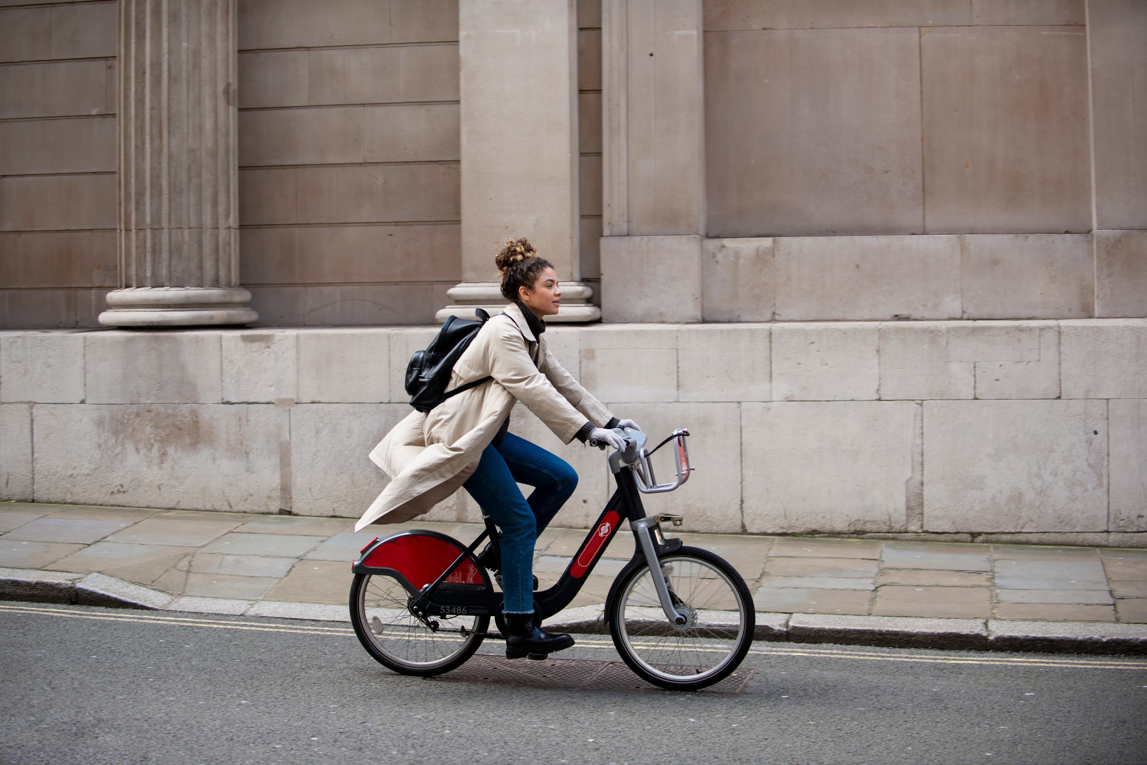 Moderne vrouw fietst op een e-bike door een zonnige, groene stad